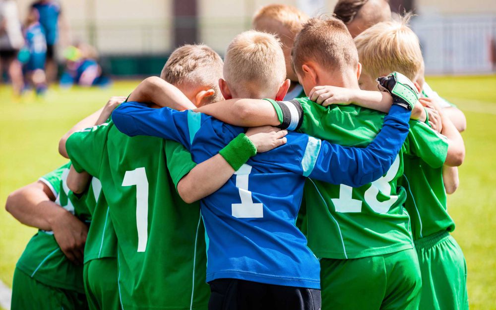 Happy boys play team sport. Kids smiling in school sports team. Children together in huddle. Cheerful children boys players of school soccer team Boys Stock Photo