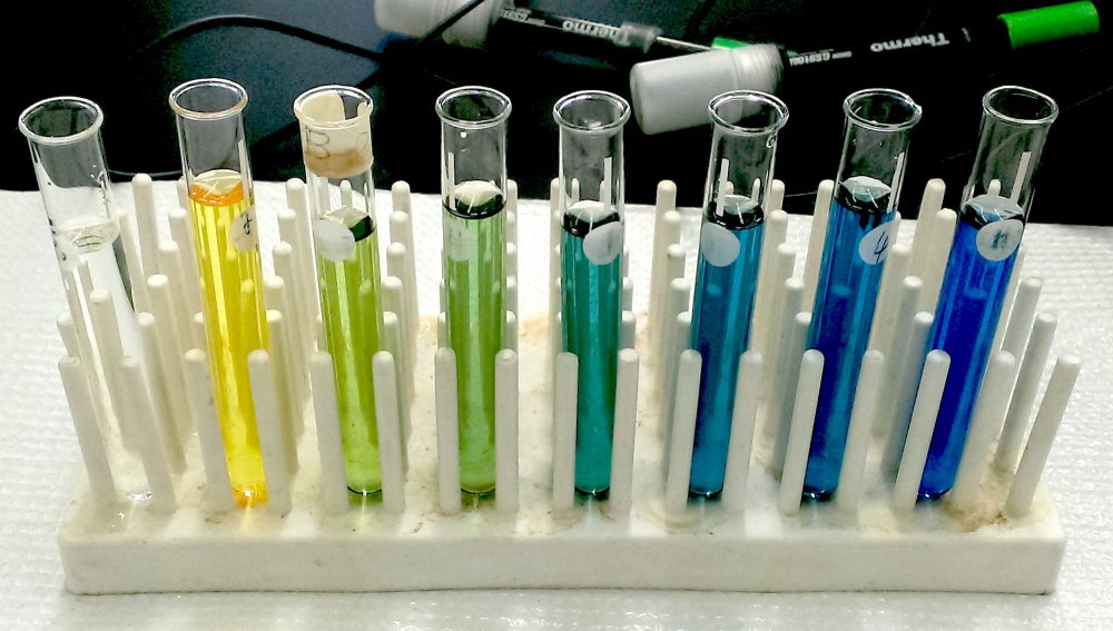 Test tubes showing the different colors of bromothymol blue (from left to right: blank, pH 4, 6.2, 6.6, 7.2, 7.5, 8, and 12).