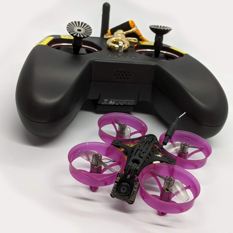 A black transmitter with purple tiny whoop drone.