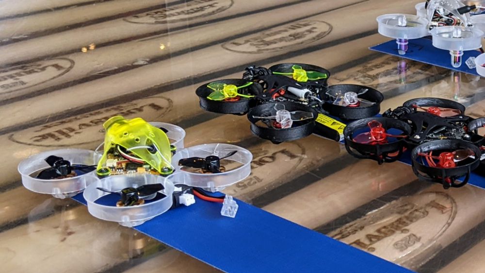 Tiny whoop drones lined up for practice flights.