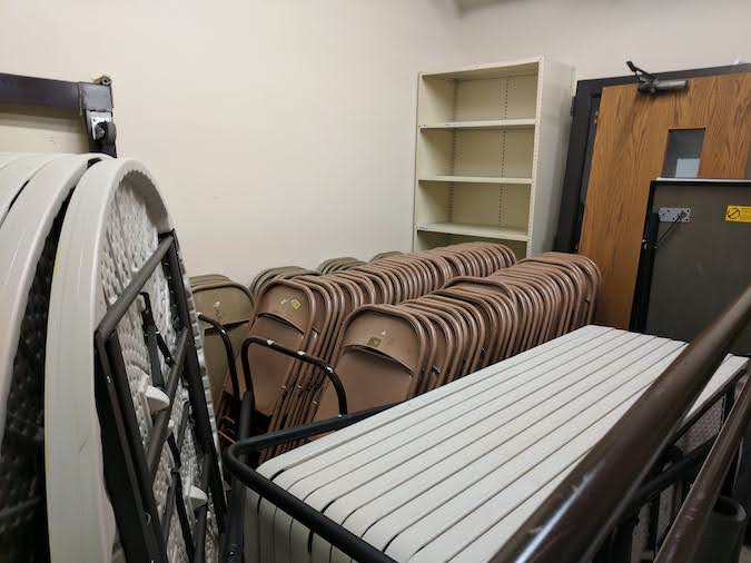 racks of folding tables and chairs in the Fellowship Hall closet