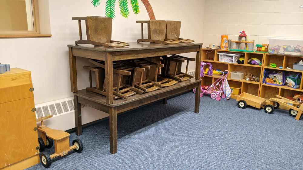 preschool tables and chairs stacked off to the side